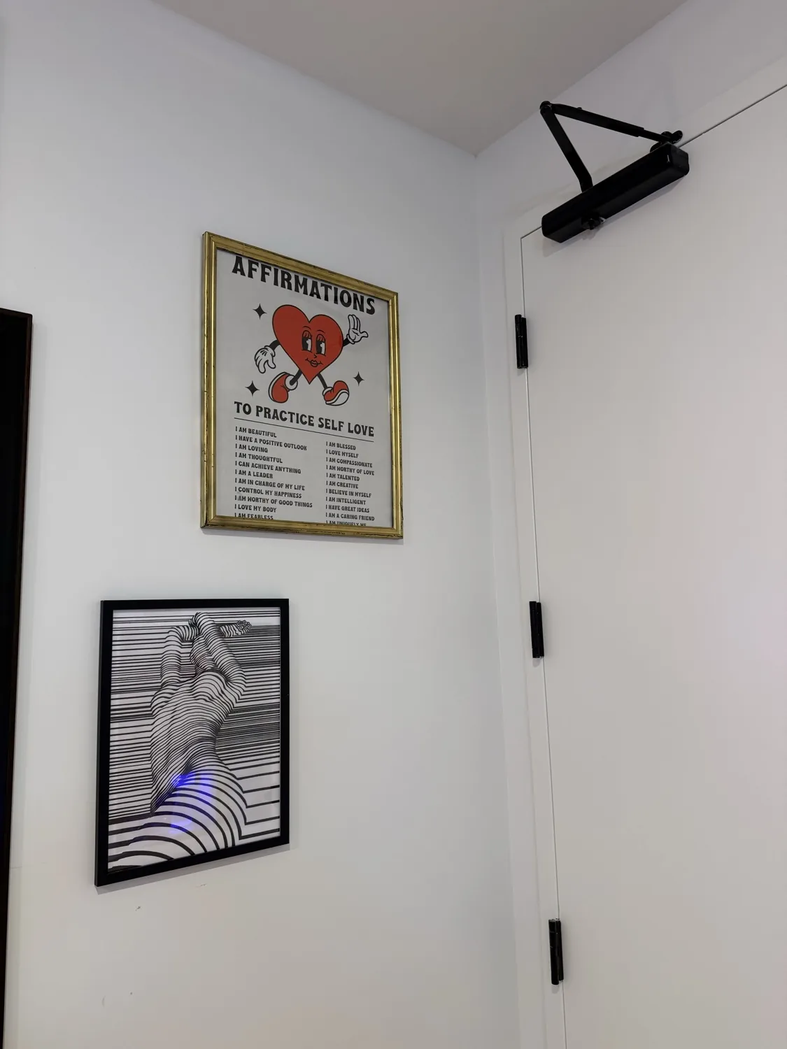 Framed 'Affirmations to practice self love' poster on the studio wall