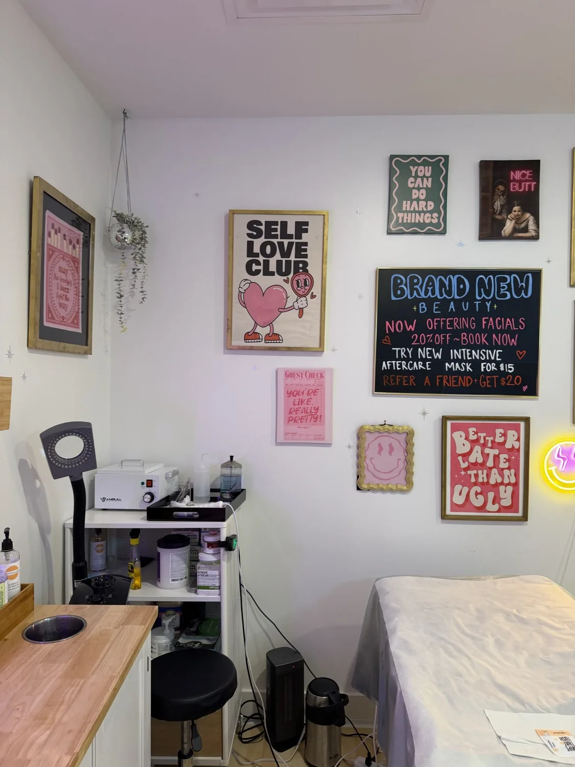 Self Love Club gallery wall beside the treatment bed