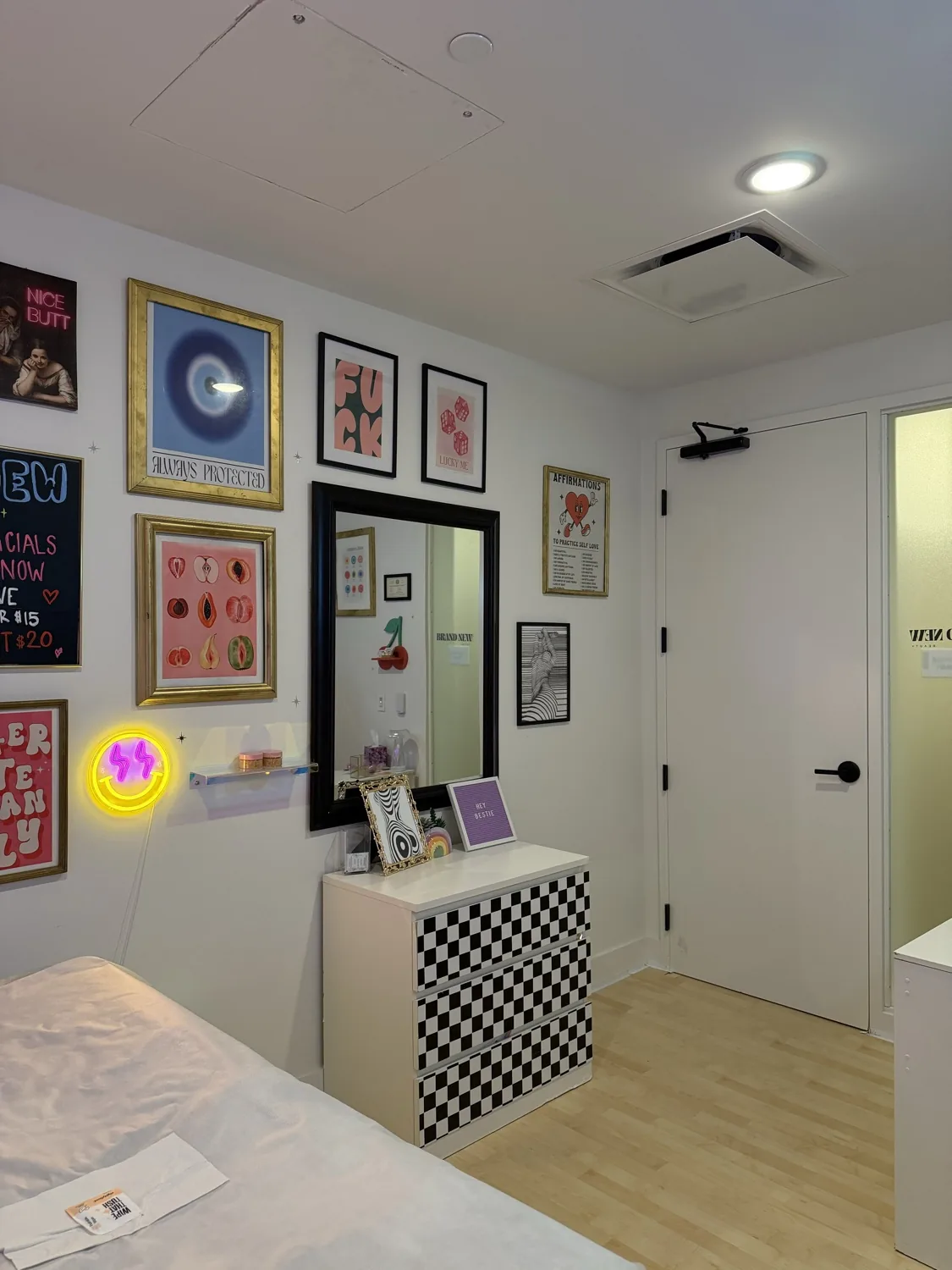 Studio corner with a checkerboard dresser and neon accents