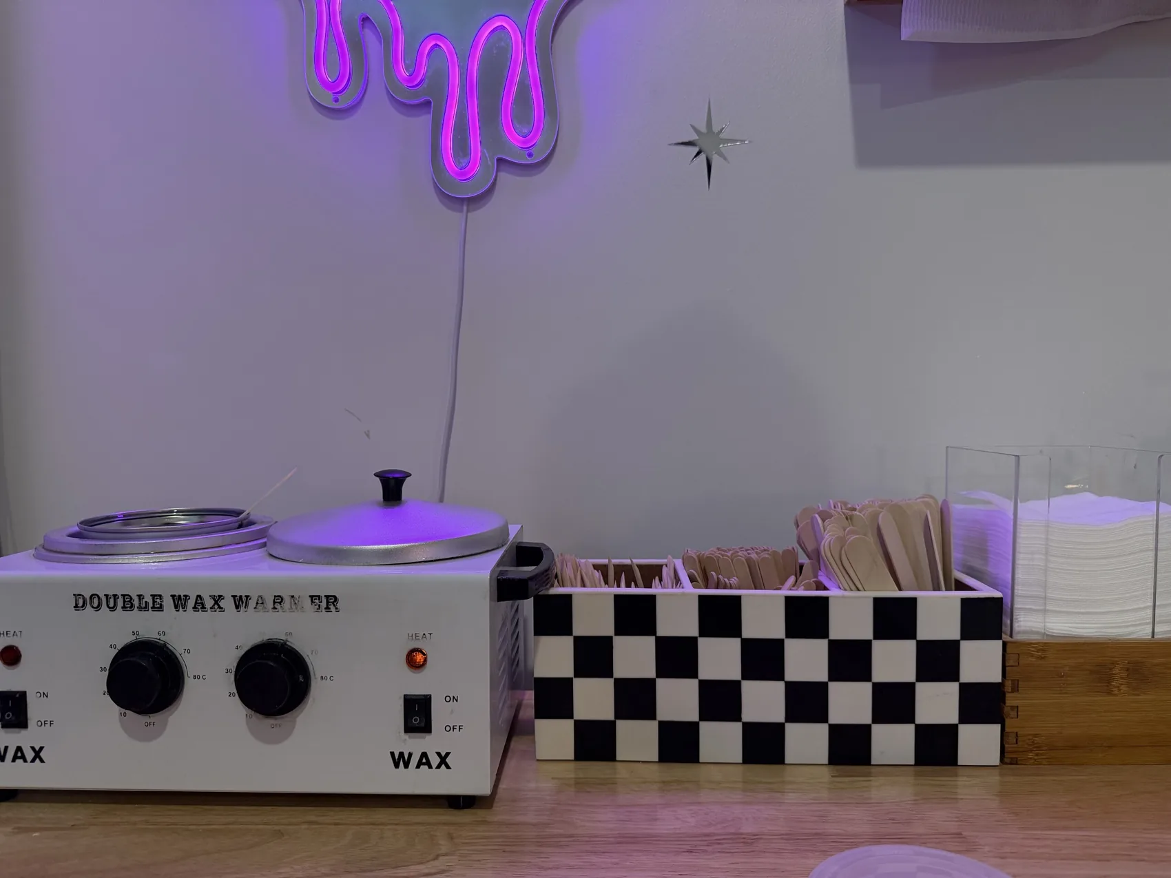 Double wax warmer glowing under a pink dripping-heart neon